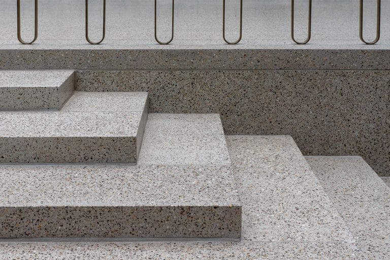 Cầu thang bê tông mài terrazzo với lan can kim loại - vật liệu hoàn thiện 2026